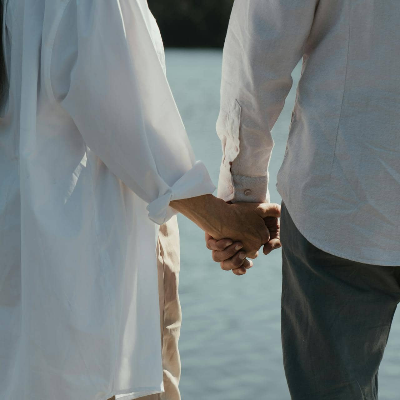 Couple wearing white long sleeves holding hands