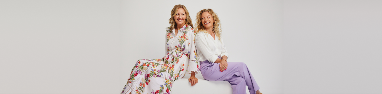 Eir Founders Kate in floral dress and Lisa in purple pants and white shirt laughing