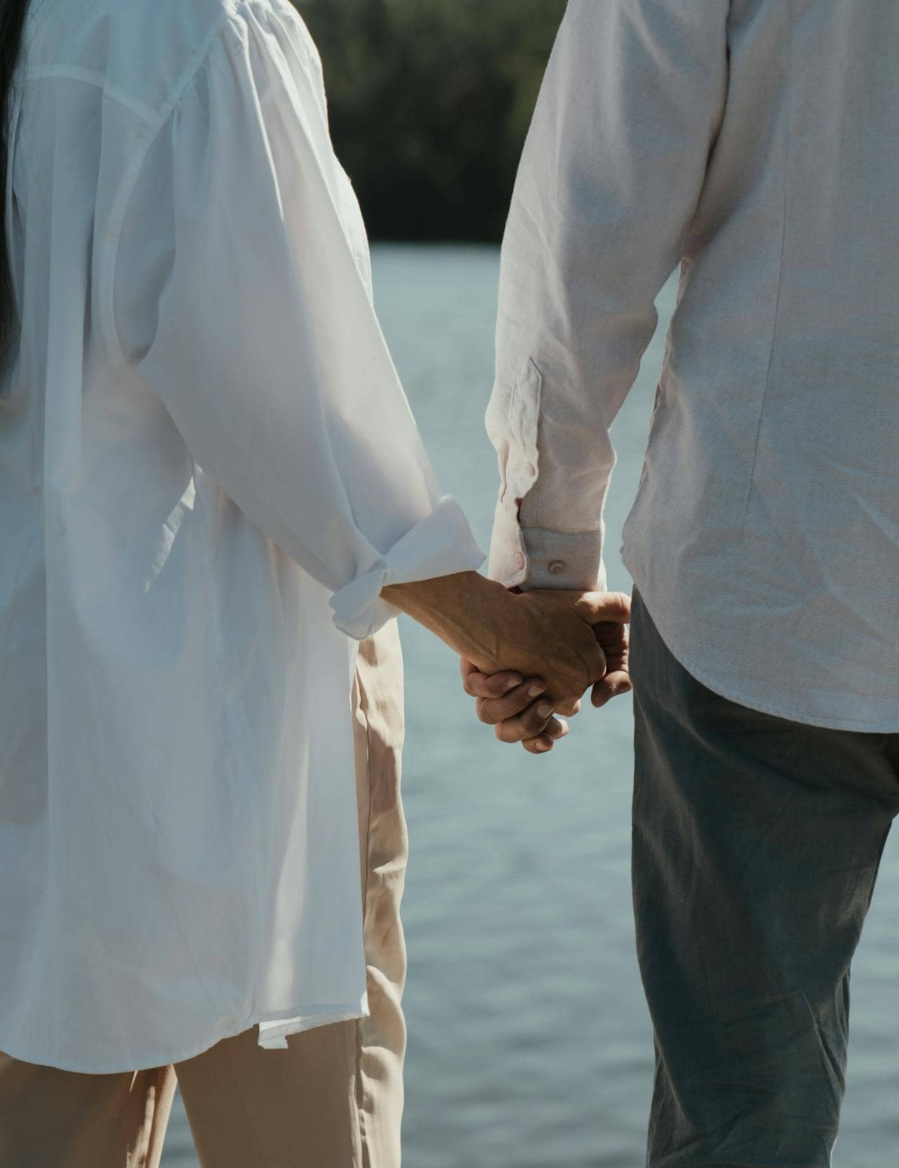 Couple wearing white long sleeves holding hands