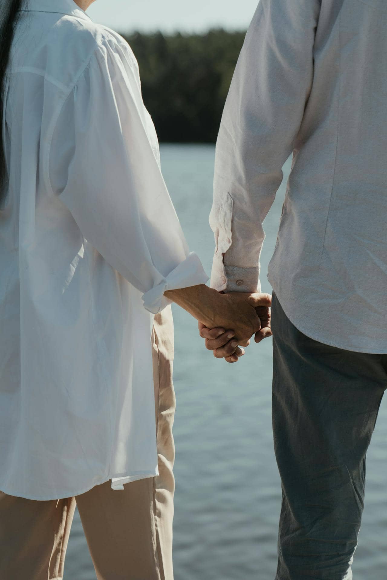 Couple wearing white long sleeves holding hands