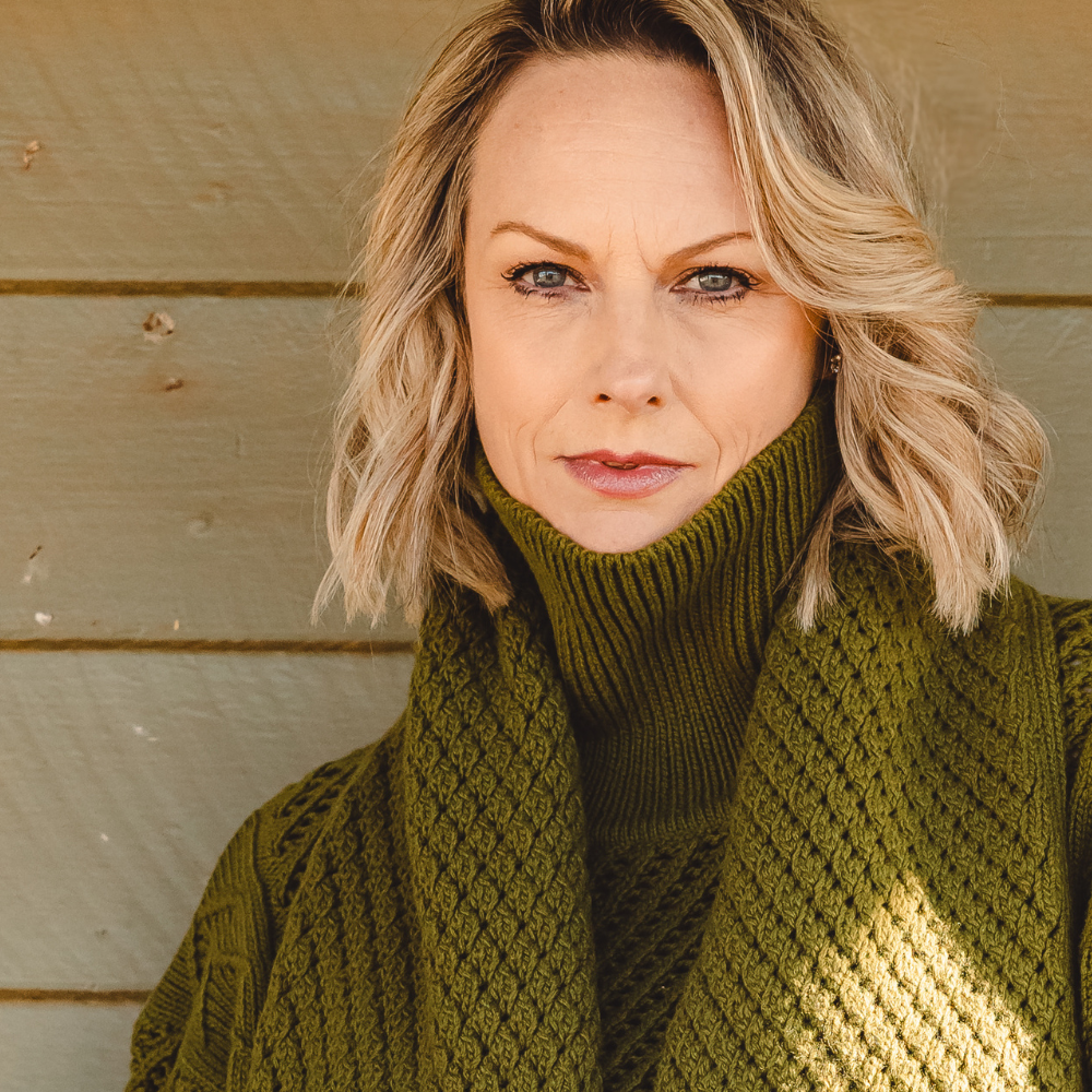 Vanessa Bell wearing an olive green knit sweater and scarf.