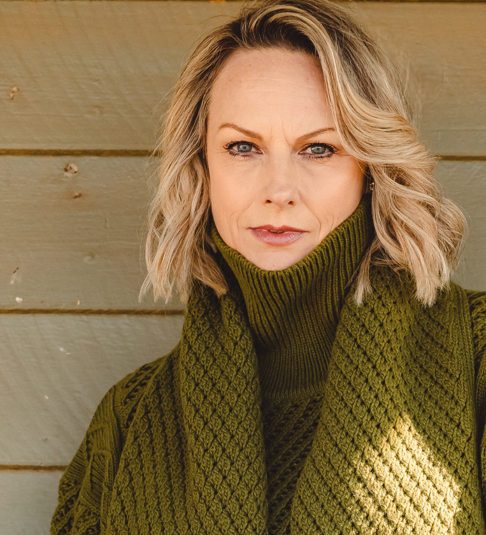 Vanessa Bell wearing an olive green knit sweater and scarf.