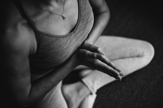 black and white image of woman sitting cross-legged in yoga pose