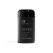 black glass vitamin bottle with pink writing